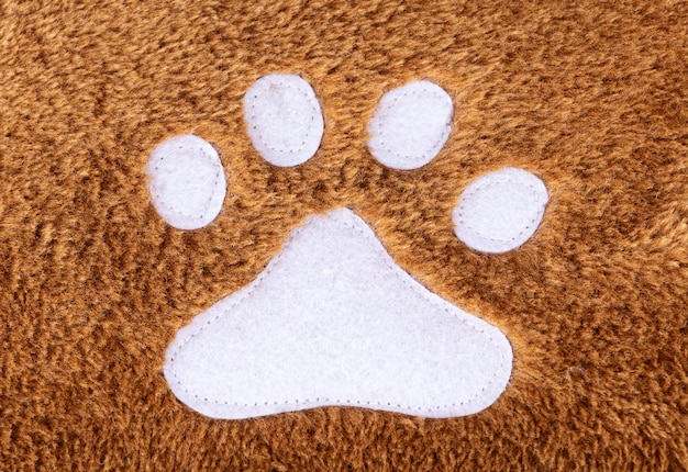 Brown wool rug texture with white cat footprint