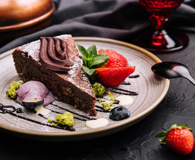 Brownie cake with a scoop of vanilla ice cream and strawberries