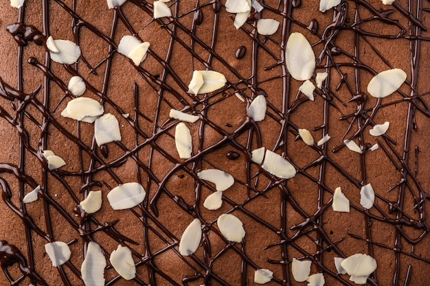 Brownie with chocolate and almond petals close up food background