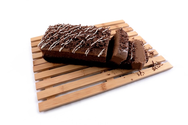 Brownies cake with chocolate flavor powdered by pieces of chocolate nut bar on a white background