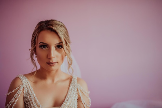 Brunet bride posing in pink studio