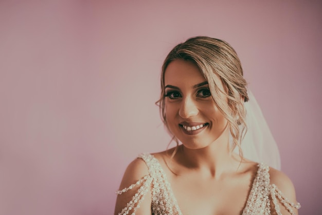 Brunet bride posing in pink studio