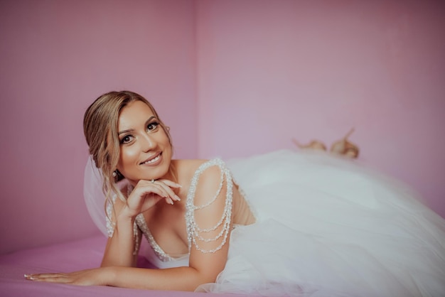 Brunet bride posing in pink studio