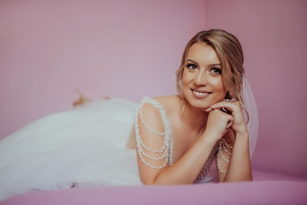 Brunet bride posing in pink studio