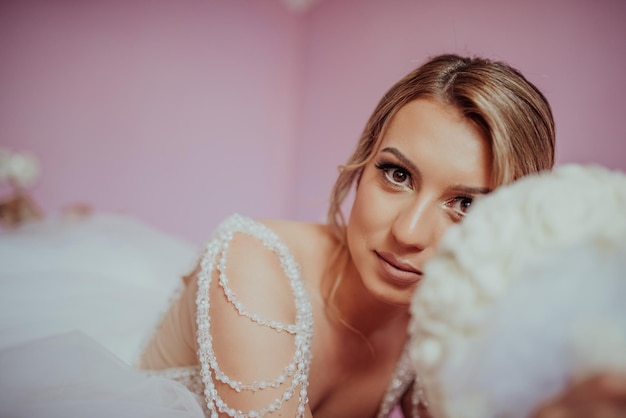 Brunet bride posing in pink studio