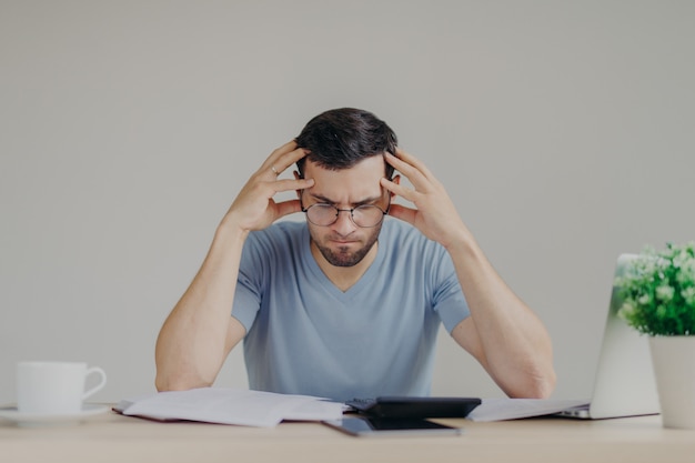 Brunet young male faces financial problems, not able to pay out mortgage, has desperate expression