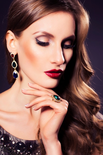 Brunette beautiful luxury woman with evening dark make up: green cat eye and brown eyeshadows. Waved hairstyle.