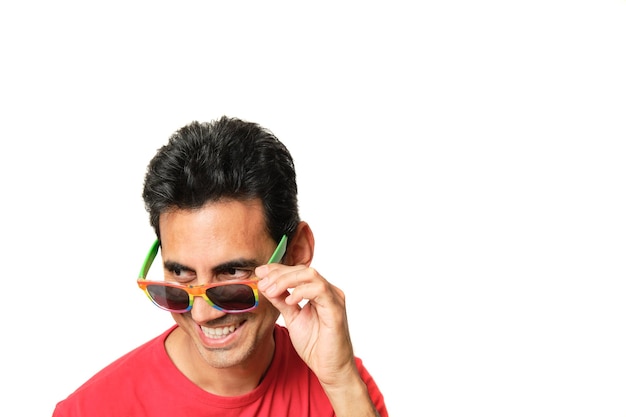 Brunette boy smiling looking to the side with lgbtq rainbow glasses in red tshirt