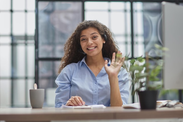 Brunette business woman using headset to communicate and advise people in customer service office