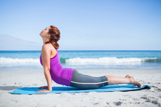 Brunette doing yoga on exercise mat