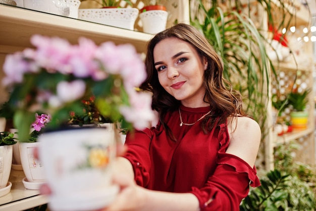 Brunette girl in red buy flowers at flower store