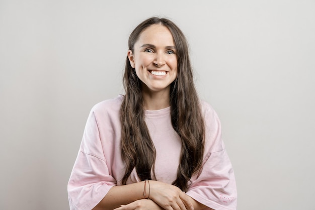 Brunette girl with long hair on a gray background