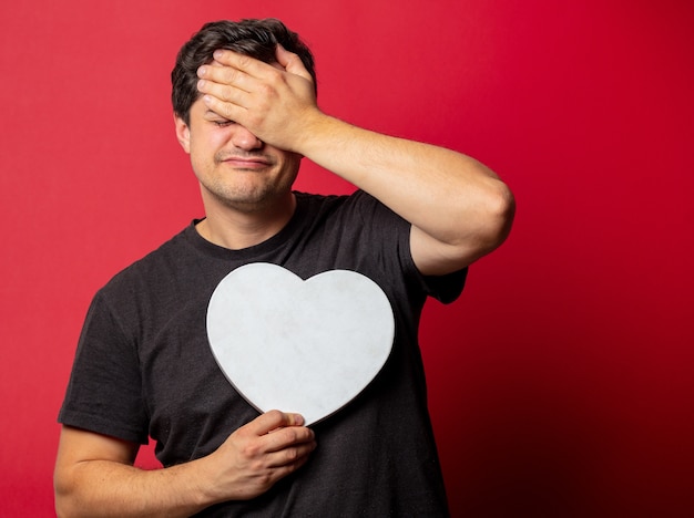 Brunette guy with heart shape on red space