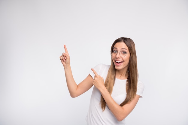 brunette lady with glasses posing against the white wall