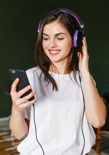 Brunette longhaired woman wearing white t-shirt listening her favorite songs