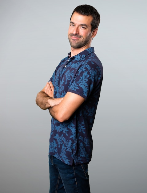 Brunette man with his arms crossed on grey background