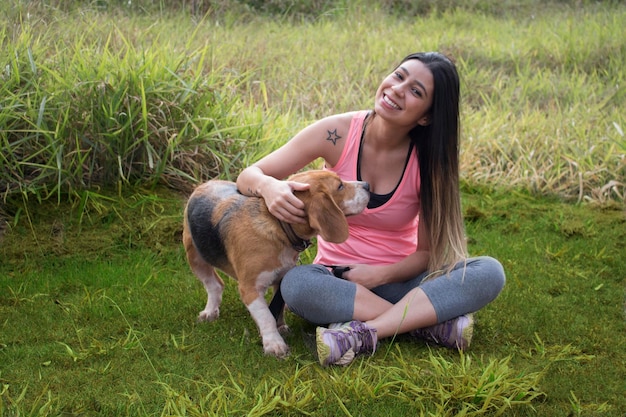 Brunette teenager with beagle dog in the park outdoors