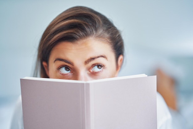 Brunette woman on bad with notepad or book