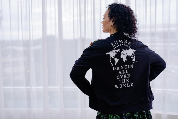 Brunette woman in black jacket with inscription Zumba Dancing