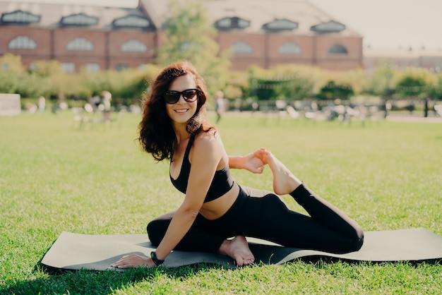 brunette woman dressed in sportswear working out outside