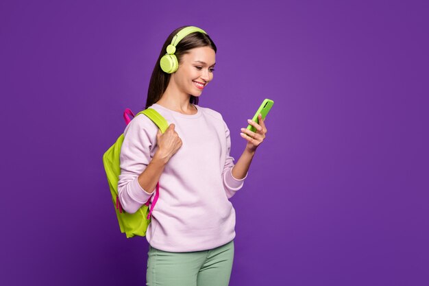 Photo brunette woman in pastel sweater posing against the purple wall