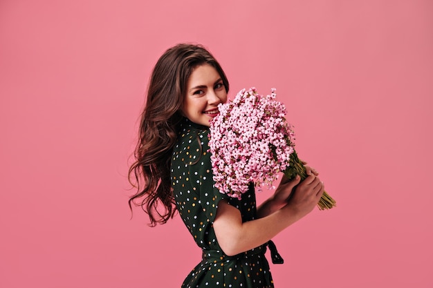 Brunette woman smiling and holding pink bouquet