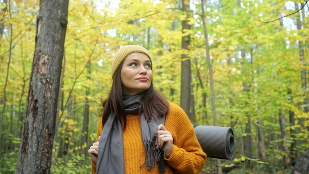 Brunette woman walks among trees and explores forest nature