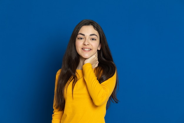 Brunette young girl wearing yellow sweatshirt