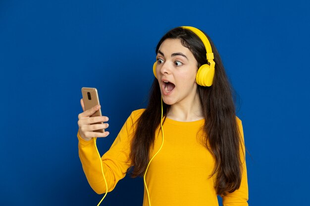 Brunette young girl wearing yellow sweatshirt