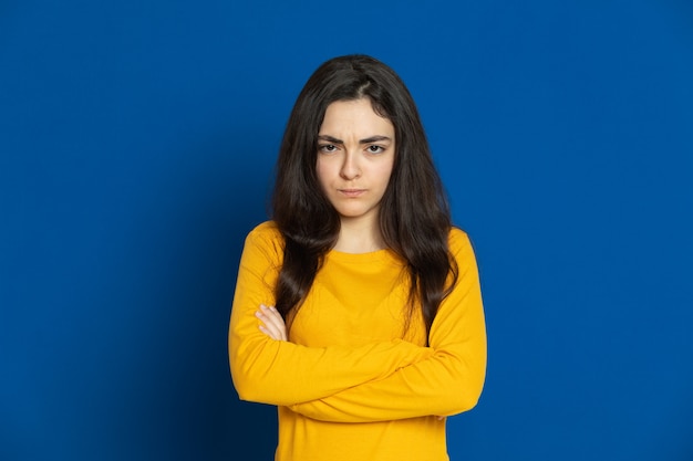 Brunette young girl wearing yellow sweatshirt