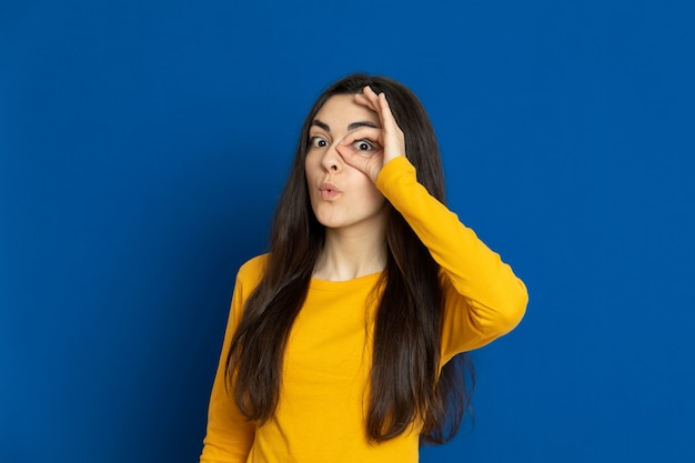 Brunette young girl wearing yellow sweatshirt