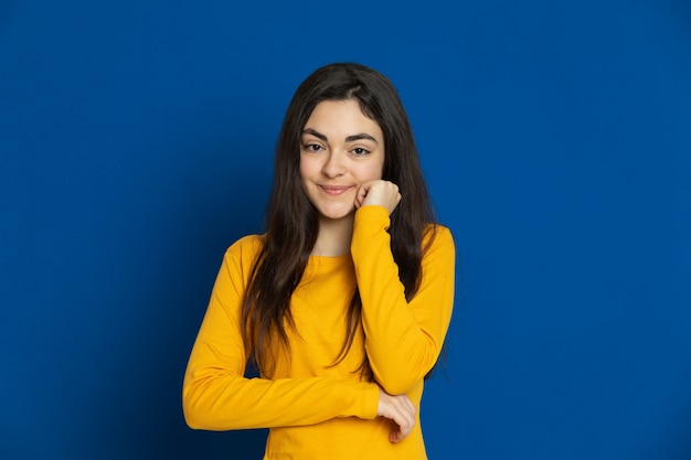 Brunette young girl wearing yellow sweatshirt