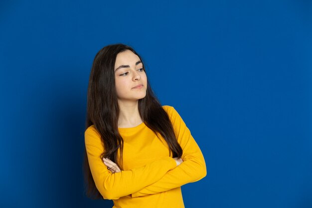 Brunette young girl wearing yellow sweatshirt