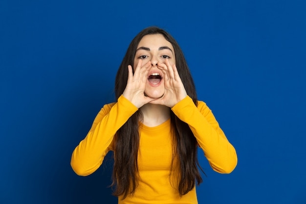 Brunette young girl wearing yellow sweatshirt