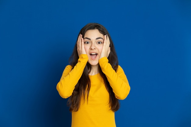 Brunette young girl wearing yellow sweatshirt