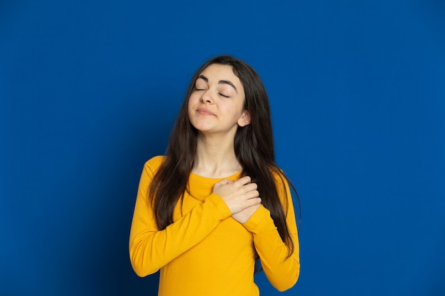 Brunette young girl wearing yellow sweatshirt