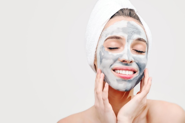 Brunette young woman doing cosmetic mask on her face