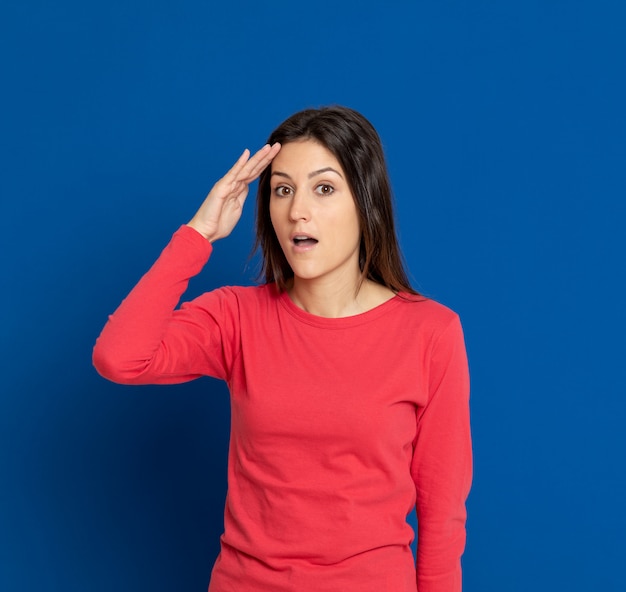 Brunette young woman gesturing over blue wall