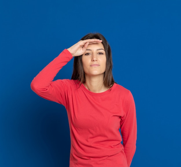 Brunette young woman gesturing over blue wall