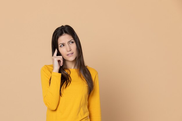 Brunette young woman wearing a yellow T-shirt