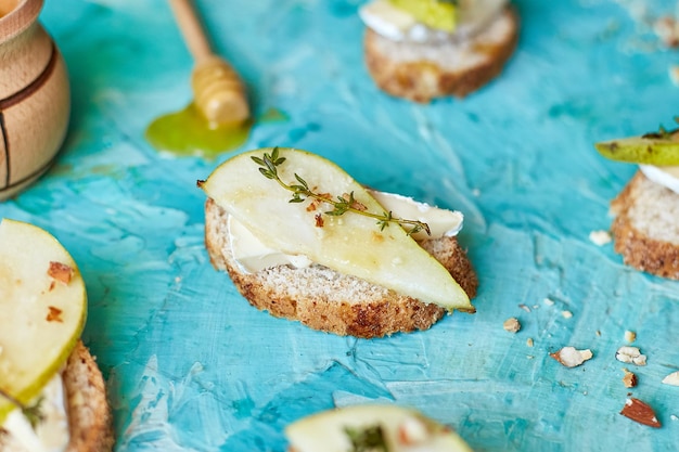 Bruschetta antipasto with blue cheese and pear on blue background