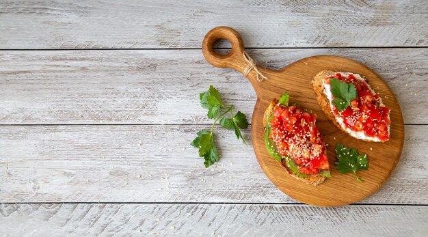 Bruschetta with cottage cheese avocado tomatoes greens white sesame seeds Healthy food rich in healthy fats fiber vitamins antioxidants Vegetarian food