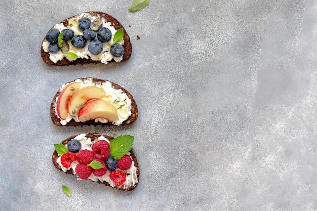 Bruschetta with cottage cheese, blueberry, raspberry, mint leaves, nectarine