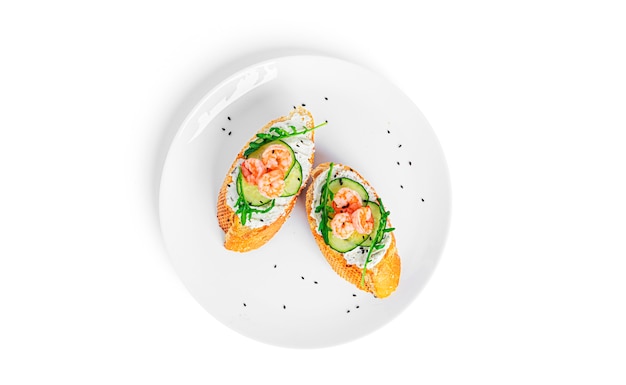 Bruschetta with cream cheese, shrimps, cucumber and arugula leaves isolated. Toast isolated. Sandwich isolated. Sandwich with shrimps, salmon and cheese