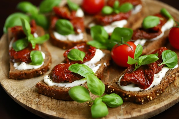 Bruschetta with dried tomatoes and basil Open sandwiches on rye bread with tomatoes