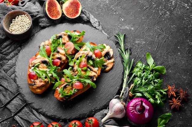 Bruschetta with mushrooms arugula grapes and feta cheese Free space for your text Top view