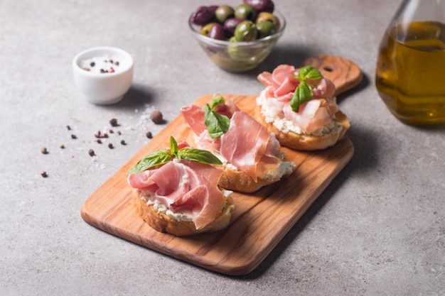 Bruschetta with prosciutto basil olives spices and herbs Appetizers