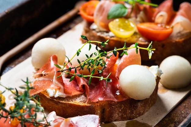 Bruschetta with prosciutto and pesto sauce on plate Bruschetta with hamon melon and honey Spanish appetizer Italian antipasti