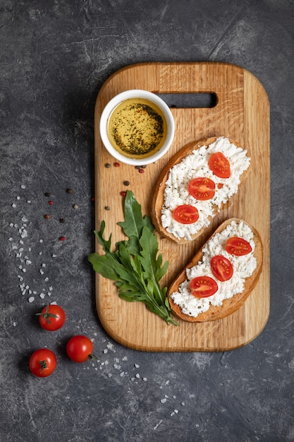 Bruschetta with roasted tomatoes and mozzarella cheese on a cutting board