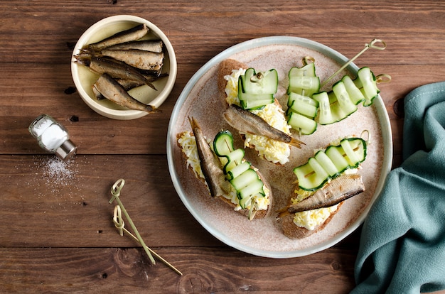 Bruschetta with sprats, egg and cucumber